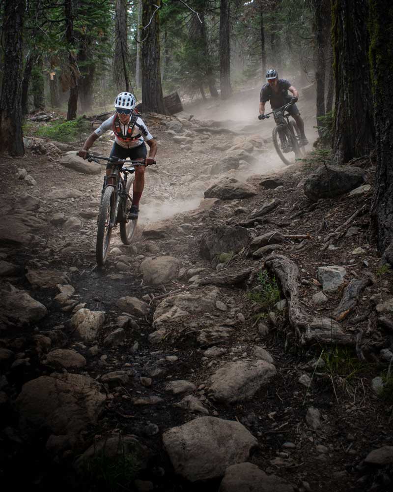 mountain bike racers riding through rocks