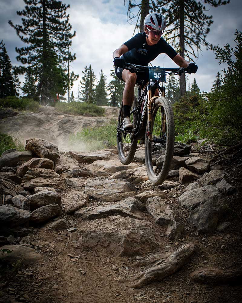 mountain bike racer catching air on rocks