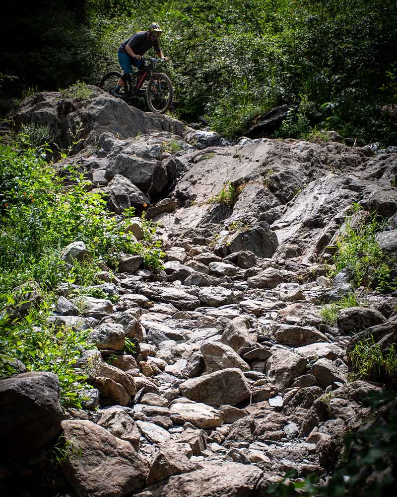 Mountain bike racer in waterfall rocks